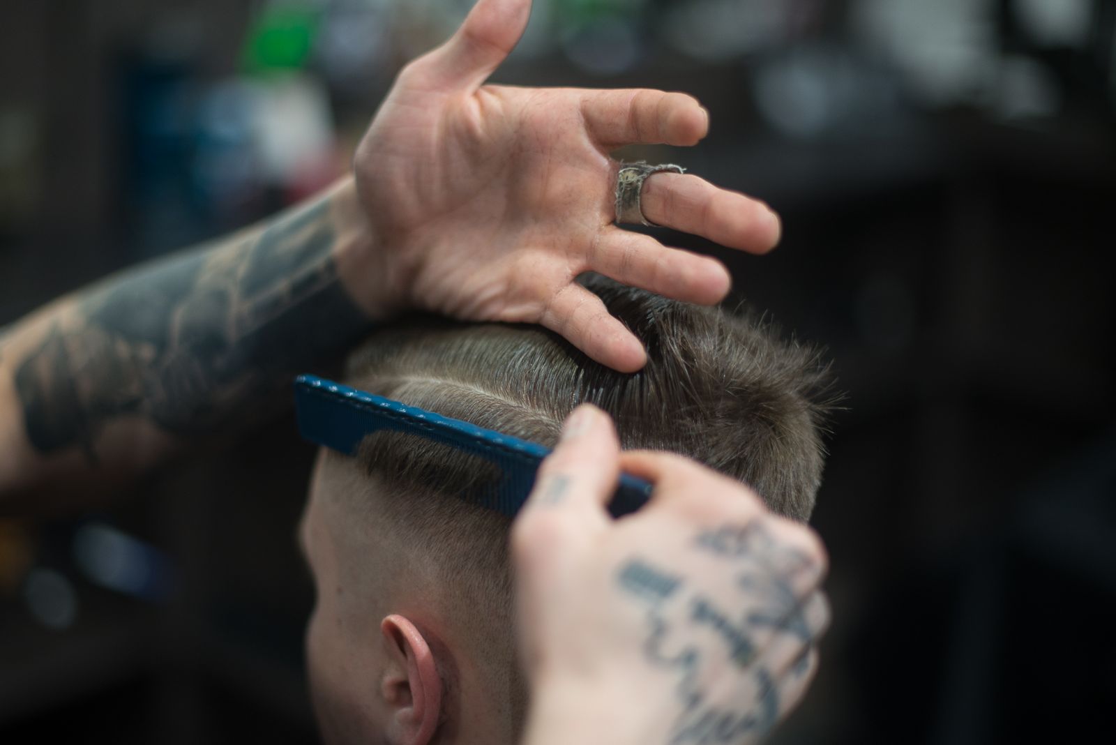 Barbeiro dando acabamento em corte de cabelo masculino
